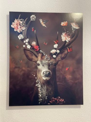 a painting of a deer with flowers on its head at Chalet Wildenbach by Interhome in Grafenweg