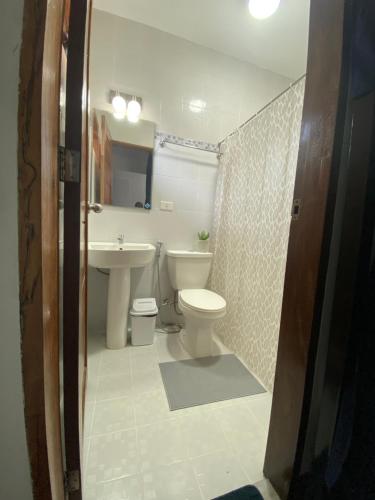 a bathroom with a toilet and a sink at MyGuide Travellers Inn in Coron