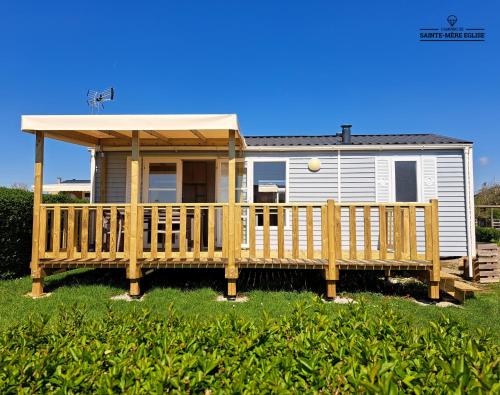 a mobile home with a deck and a gazebo at Camping Sainte Mère Eglise in Sainte-Mère-Église