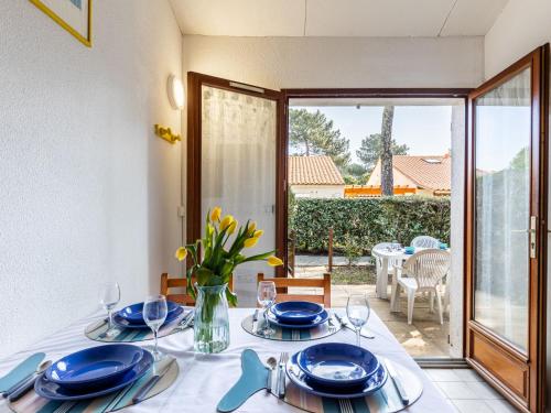 una sala da pranzo con tavolo e piatti blu di Holiday Home Hameau de Talaris-4 by Interhome a La Palmyre
