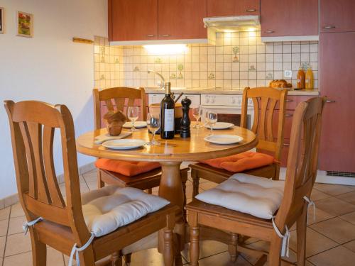 a wooden table with chairs and a bottle of wine at Apartment Heida A 5 by Interhome in Ovronnaz