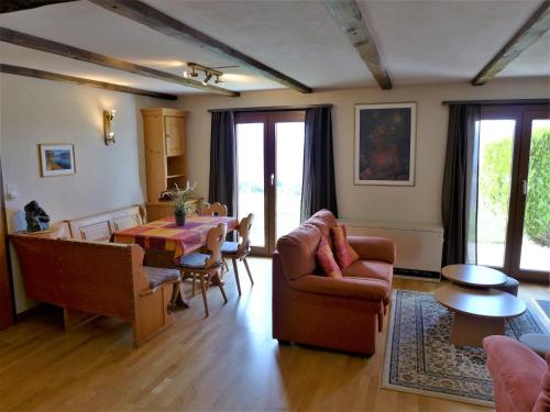 sala de estar con sofá, mesa y sillas en Chalet Praline by Interhome, en Icogne