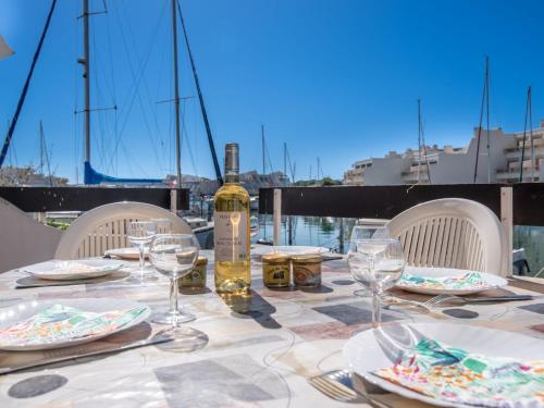 a table with a bottle of wine and glasses at Apartment Les Marinas de la Plage I-1 by Interhome in Le Grau-du-Roi