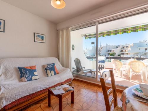 d'un salon avec un canapé et un balcon. dans l'établissement Apartment Les Marinas de la Plage I-1 by Interhome, au Grau-du-Roi