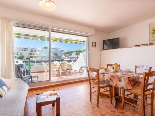 a living room with a table and a view of the ocean at Apartment Les Marinas de la Plage I-1 by Interhome in Le Grau-du-Roi