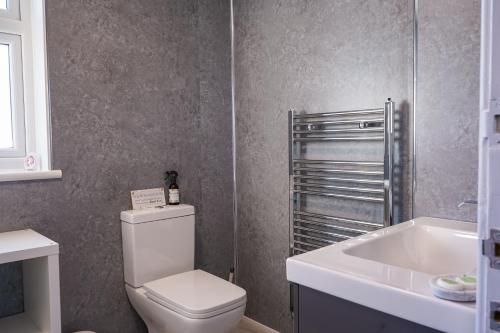 La salle de bains est pourvue de toilettes blanches et d'un lavabo. dans l'établissement Badgers Run, à Sandown