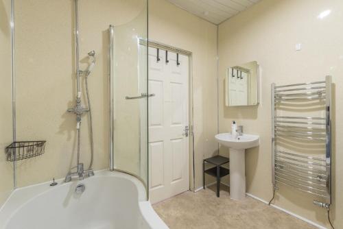 W łazience znajduje się prysznic, wanna i umywalka. w obiekcie Contemporary 3 Bed City Centre Appartment - Ensuite w Edynburgu