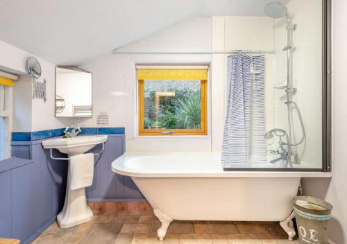 a bathroom with a white tub and a sink at Beaconsfield Bolthole in Woodbridge