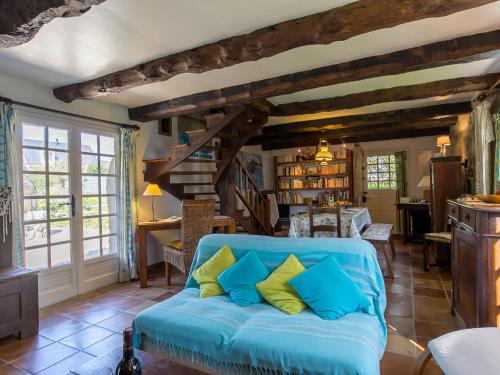 a living room with a blue couch with pillows at Holiday Home Chaumiere Natelliou by Interhome in Trégunc