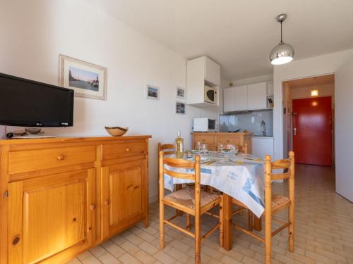 une cuisine avec une table et des chaises ainsi qu'une télévision dans l'établissement Studio Los Amigos-9 by Interhome, au Grau-du-Roi