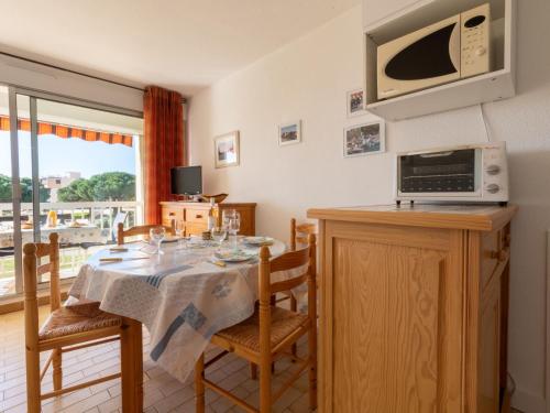 une salle à manger avec une table et un four micro-ondes dans l'établissement Studio Los Amigos-9 by Interhome, au Grau-du-Roi