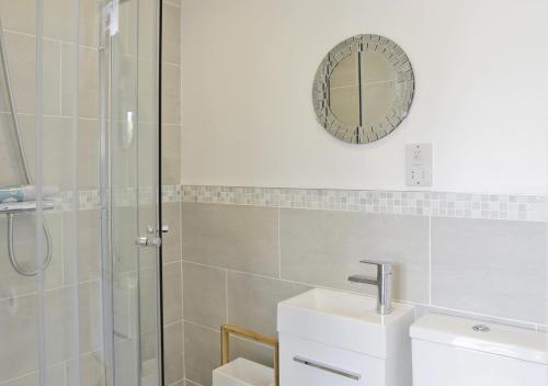 a bathroom with a shower and a sink and a mirror at Bon Amis in Southwold