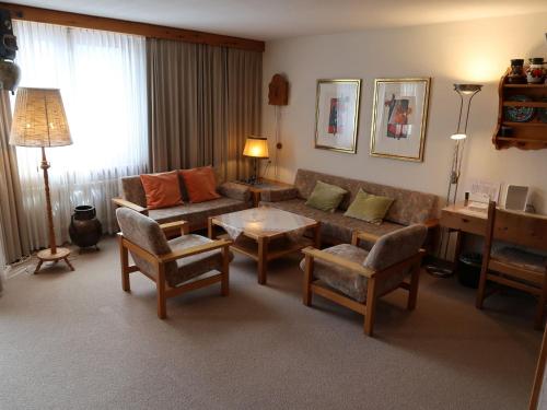ein Wohnzimmer mit einem Sofa und einem Tisch in der Unterkunft Apartment Guardaval - Utoring-33 by Interhome in Davos