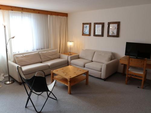 ein Wohnzimmer mit einem Sofa und einem Tisch in der Unterkunft Apartment Guardaval - Utoring-36 by Interhome in Davos