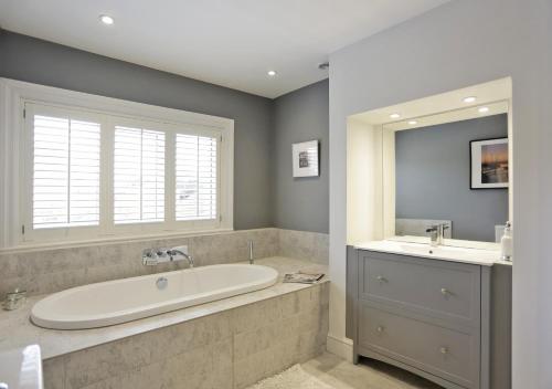 a large bathroom with a tub and a sink at Braeside House in Reydon