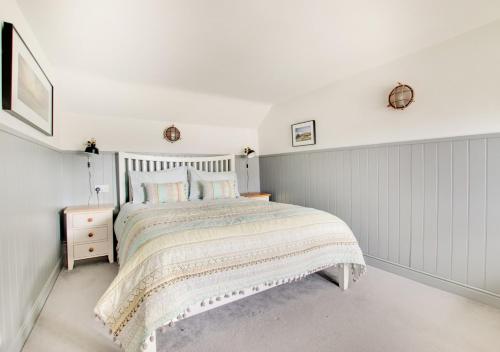Dormitorio blanco con cama y pared blanca en Box Cottage, en Snape