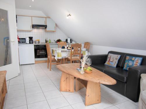 ein Wohnzimmer mit einem Tisch und einer Küche in der Unterkunft Apartment Leuchtturm by Interhome in Norddeich