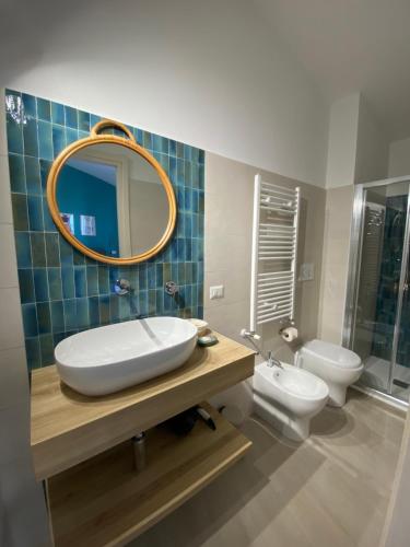W łazience znajduje się umywalka, toaleta i lustro. w obiekcie Il Timone B&B w mieście Buggerru