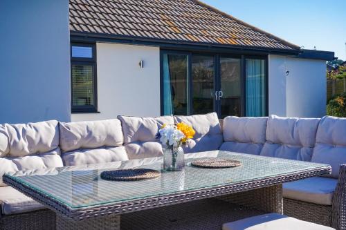 a couch and a glass table with flowers on it at Badgers Run in Sandown