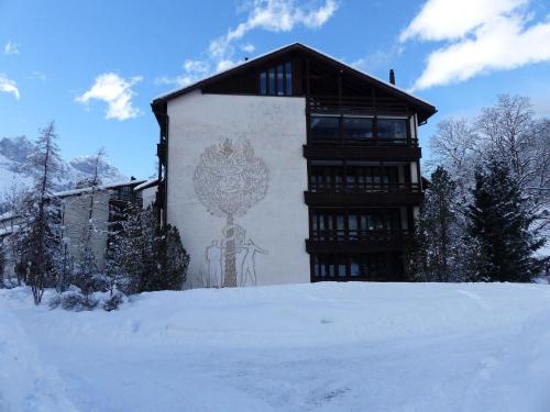 een gebouw met een schilderij erop in de sneeuw bij Apartment Am Dürrbach 5-512 by Interhome in Engelberg