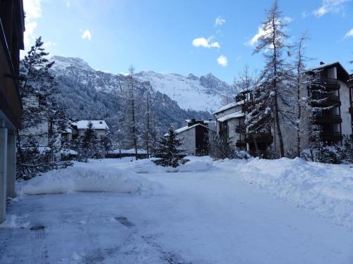 een straat bedekt met sneeuw met huizen en bergen bij Apartment Am Dürrbach 5-512 by Interhome in Engelberg