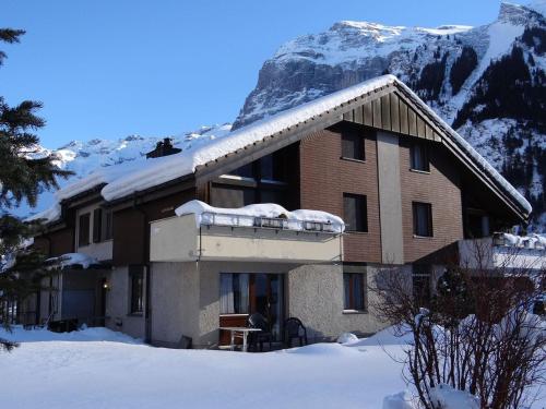 una casa con nieve en el techo frente a una montaña en Apartment Casa Lisabetha by Interhome, en Engelberg