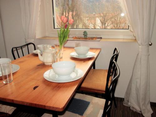 a wooden table with plates and bowls on it with a window at Apartment Kern by Interhome in Bad Hofgastein