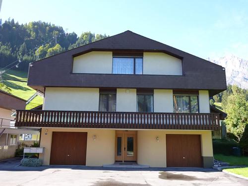 ein Haus mit schwarzem Dach und zwei Garagen in der Unterkunft Apartment Birkenstrasse 70-1 by Interhome in Engelberg