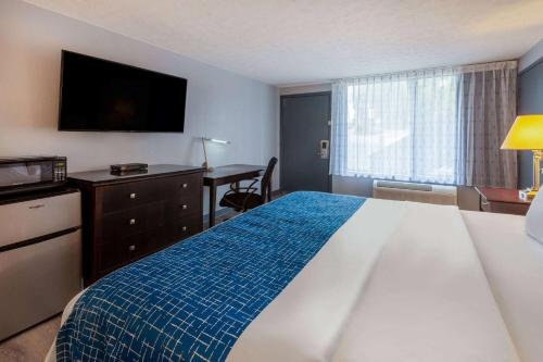 a hotel room with a large bed and a desk at Travelodge by Wyndham Charles Town - Harpers Ferry in Charles Town