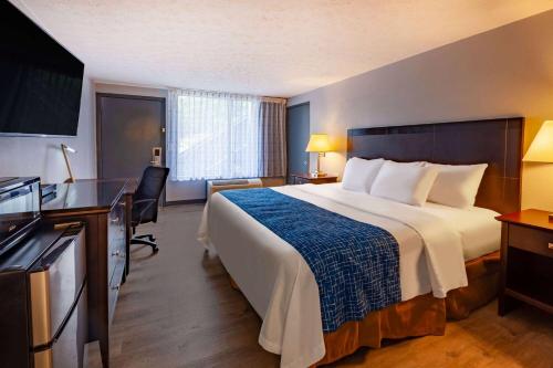 a hotel room with a large bed and a desk at Travelodge by Wyndham Charles Town - Harpers Ferry in Charles Town