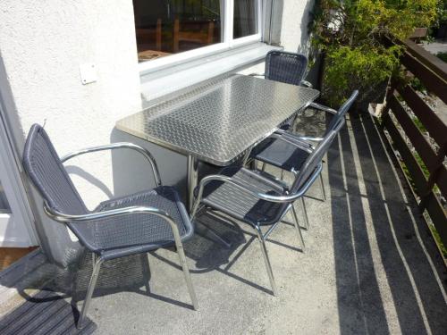 einen Tisch und vier Stühle auf einer Terrasse in der Unterkunft Apartment Birkenstrasse 52 by Interhome in Engelberg