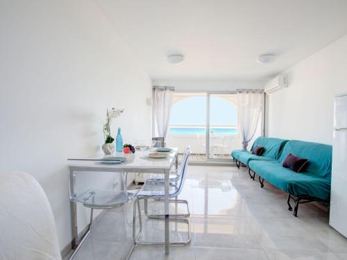 un salon avec un canapé bleu et une table dans l'établissement Studio Vistaéro-7 by Interhome, au Barcarès