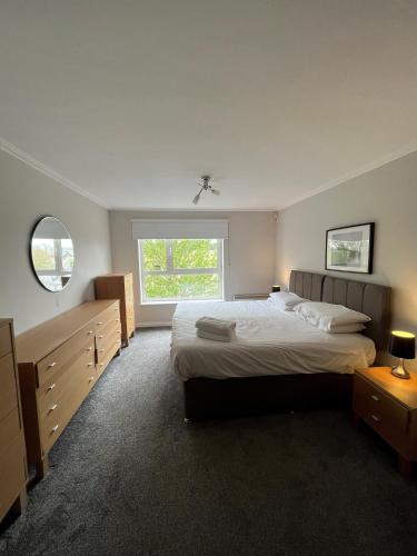 a bedroom with a large bed and a window at Century Wharf Apartments by Urban Space in Cardiff