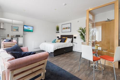 a living room with a bed and a table and chairs at Exeter City Centre Apartments Ashton Apartment in Exeter