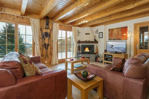 a living room with two couches and a television at Chalet Mont Rose in La Tzoumaz