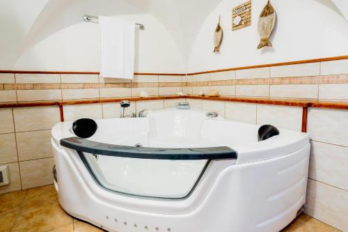 eine Badewanne im Bad mit gefliesten Wänden in der Unterkunft Sanremo Amazing Apartment with Private Parking in Sanremo