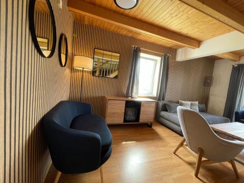 - un salon avec un fauteuil bleu et un canapé dans l'établissement Holiday Home Holiday Hill 59 by Interhome, à Lauterwasser