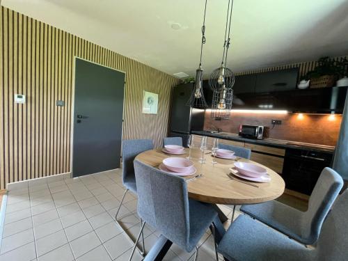 une cuisine avec une table en bois et des chaises bleues dans l'établissement Holiday Home Holiday Hill 59 by Interhome, à Lauterwasser