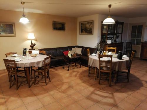 uma sala de estar com duas mesas e um sofá em Frairie Du Divit em Pontivy