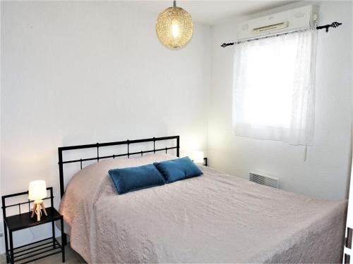 une chambre avec un lit avec un oreiller bleu dessus dans l'établissement Apartment Les Grandes Bleues 2-5 by Interhome, à Narbonne-Plage