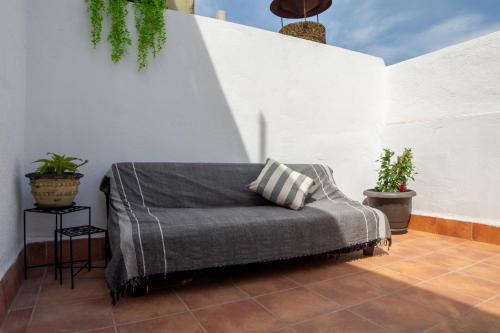 eine Couch auf einer Terrasse mit Pflanzen in der Unterkunft Amadeu 1, Calella in Calella