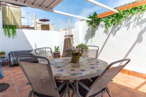 einen Tisch und Stühle auf einer Terrasse mit einem Tisch in der Unterkunft Amadeu 1, Calella in Calella