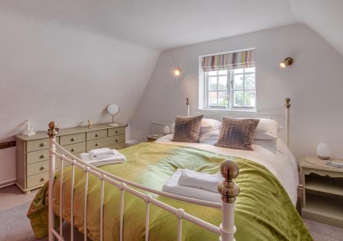 a bedroom with a large bed and a window at Church Cottage in Wangford