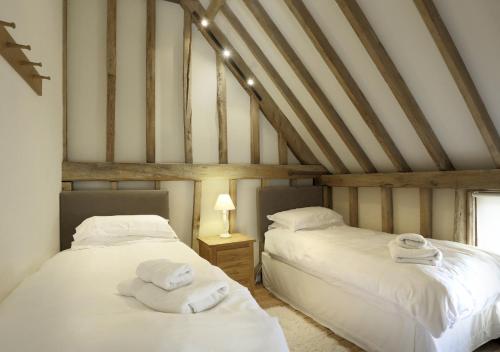 two beds in a attic room with white sheets at Christmas Cottage Sternfield in Friston