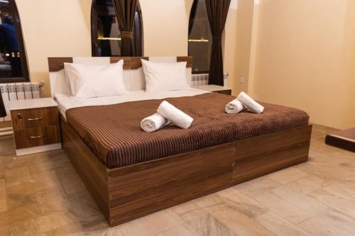 a bedroom with a large bed with two pillows on it at Qala Hostel Ganja in Ganja