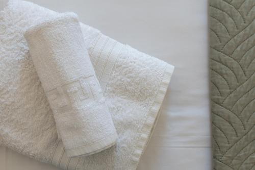 uma toalha branca sentada em cima de uma cama em The Panorama House em Pera Gyalos