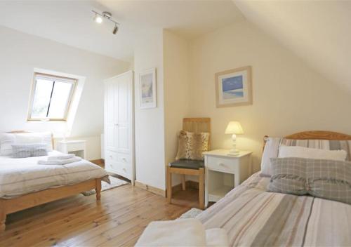 a bedroom with two beds and a table with a lamp at Cedar in Lowestoft