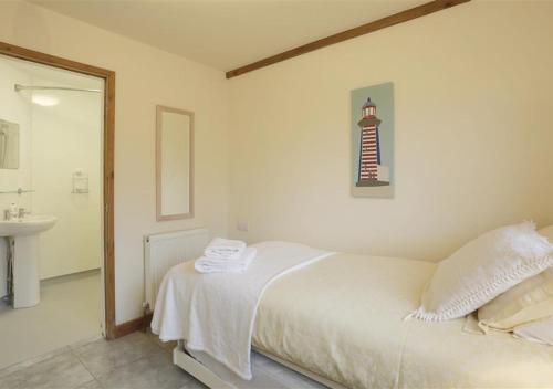 a bedroom with a bed and a bathroom with a sink at Cedar in Lowestoft