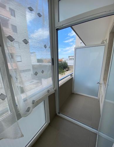 a room with a large window and a white door at IRIS ROOM in Monopoli