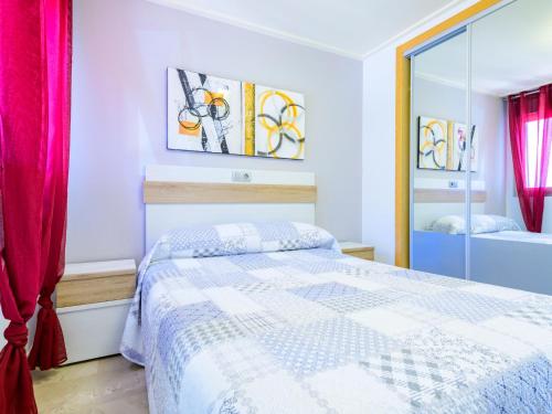 a white bedroom with a bed and a mirror at Apartment Vila de Oropesa X by Interhome in Oropesa del Mar